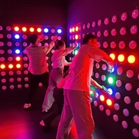 Commercial interactive push button game wall with glowing LED lights.