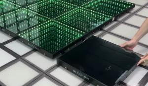 Technician demonstrating the fast magnetic snap installation of an LED dance floor panel, showing tool-free and cable-free setup.