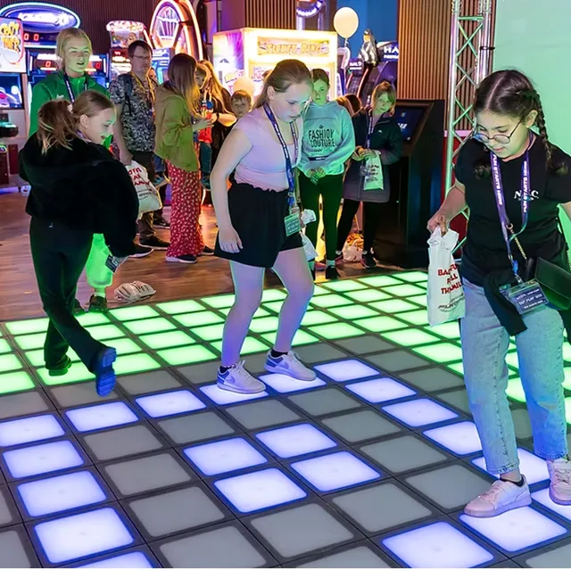 Interactive game floor used as an eye-catching attraction at exhibitions and event spaces, drawing crowds through motion-based gameplay.