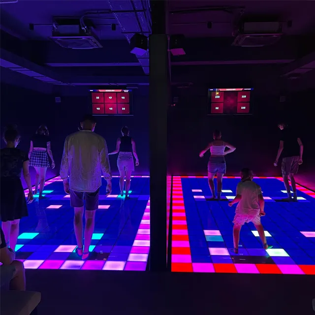 Team-based interactive floor games where players compete together by stepping on dynamic lighting targets.