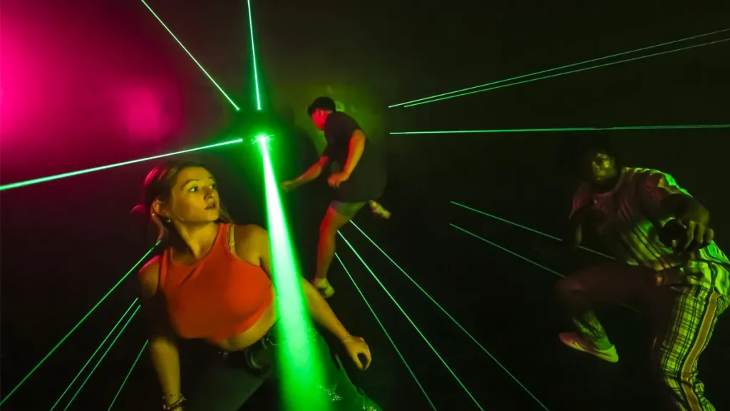 Mega Laser – Interactive Game Room Experience (2025) 3 Players actively participating in Mega Laser game, avoiding laser beams.
