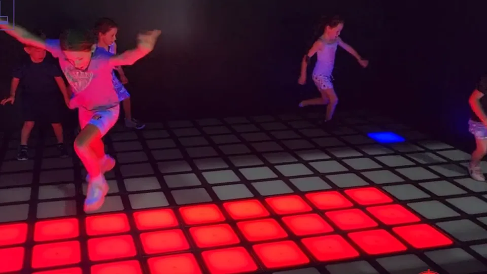 Children and adults competing and cooperating on the Vitcor Interactive Game Floor