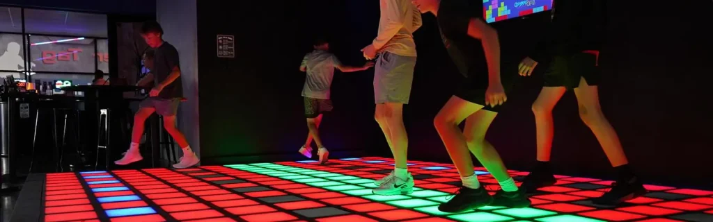 players interacting in an activate games room with LED floor and sensor walls