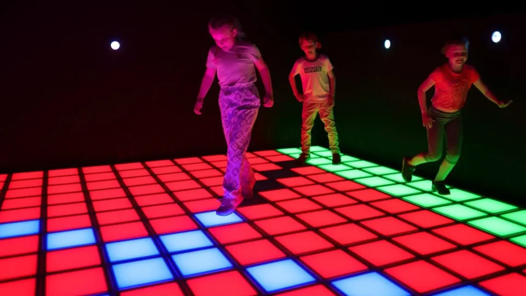 Diagram showing how an interactive game floor works with LED grid activation, player movement tracking, and real-time scoring system