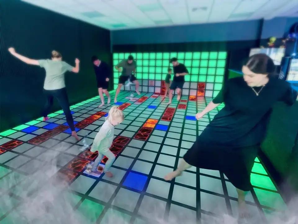 Players interacting on an interactive LED game floor at a family entertainment center