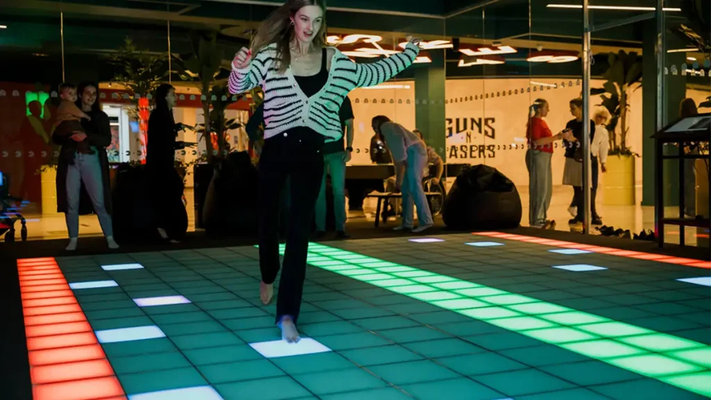 interactive pixel floor game installed in indoor entertainment venue with multiple players