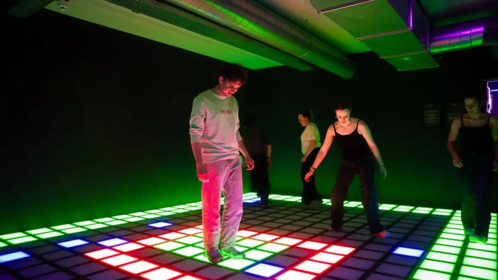 players competing in active gaming room with LED floor and wall targets