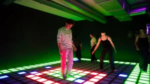 players competing in active gaming room with LED floor and wall targets