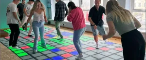 Interactive game floor installed in a commercial family entertainment center with players on the lit floor