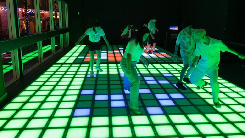 Active Gaming Room ROI: How FEC Operators Maximize Returns (2026) 1 Players on LED interactive floor inside active gaming room showing commercial ROI optimization potential for FEC operators