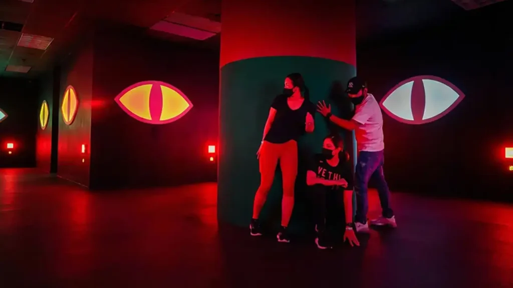 Evil Eyes Hide Game: Why Stealth Rooms Work in Active Gaming Venues (2026) 2 Player concealing behind pillar during an evil eyes hide game stealth challenge in an active gaming venue