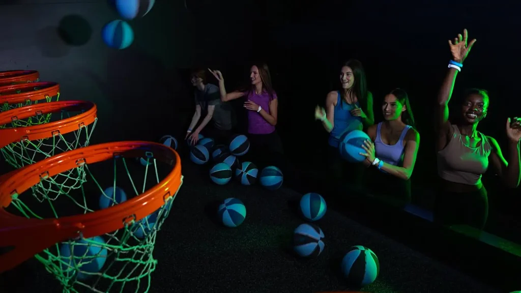 Interactive Hoops Game: Why Basketball Challenge Rooms Work in Active Gaming Venues (2026) 1 Players shooting at color-shifting LED hoops inside a commercial interactive hoops game room for FEC and active gaming venues