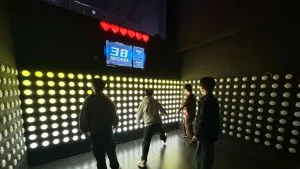 Players competing on a push button game wall inside a commercial active gaming room for FEC venues