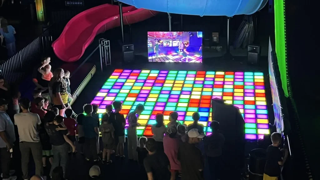 What Is Activate Games? The Business Model FEC Operators Need to Understand (2026) 1 Overview of an Activate Games style active gaming venue showing LED challenge rooms and players inside a commercial FEC