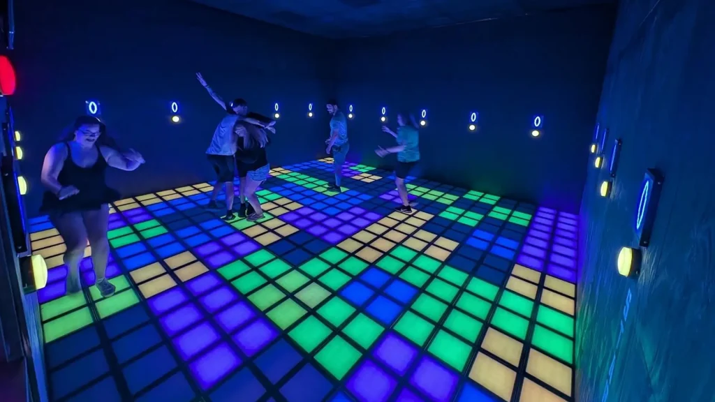 Interactive Game Floor for Schools: Gamified PE Guide (2026) 3 Students playing on an interactive game floor for schools during a recess or break period