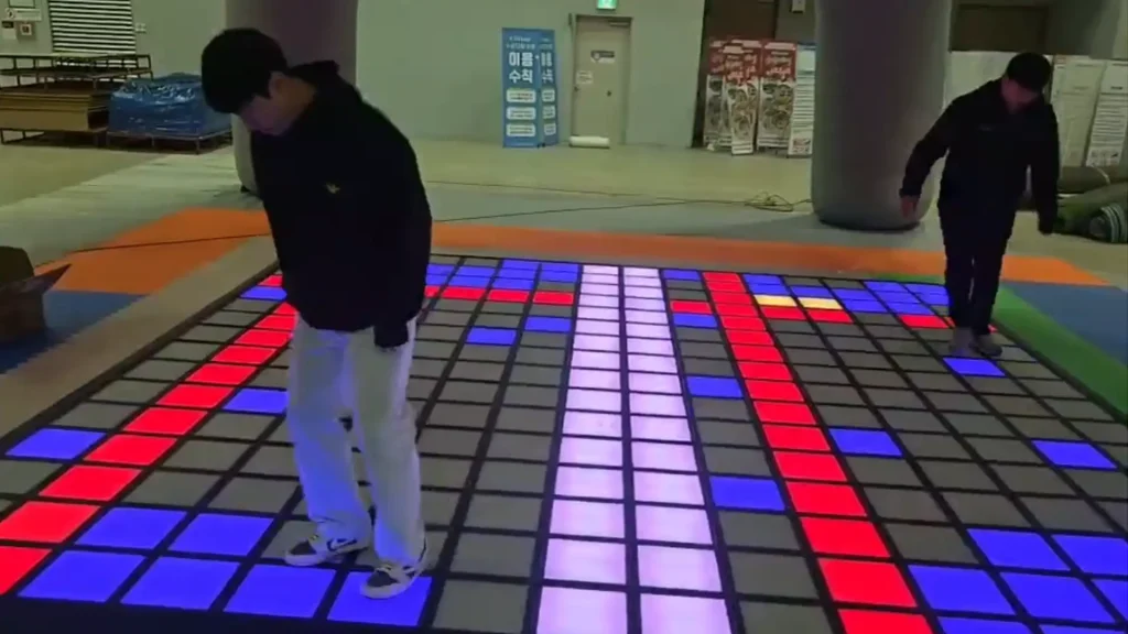 Real installed interactive game floor showing the LED grid used as a layout anchor attraction