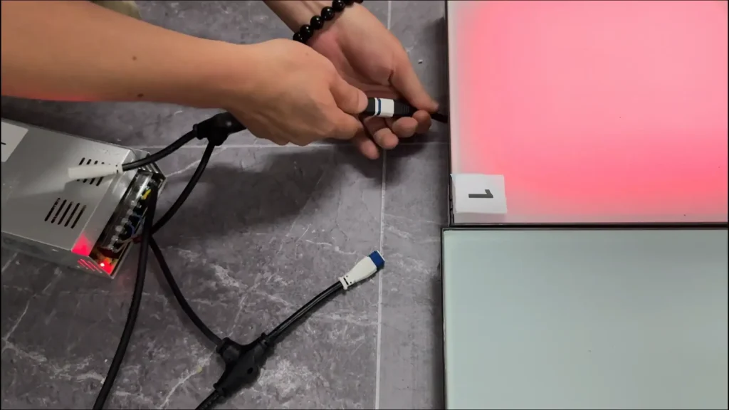 Technician inspecting a modular interactive game floor tile and controller connection
